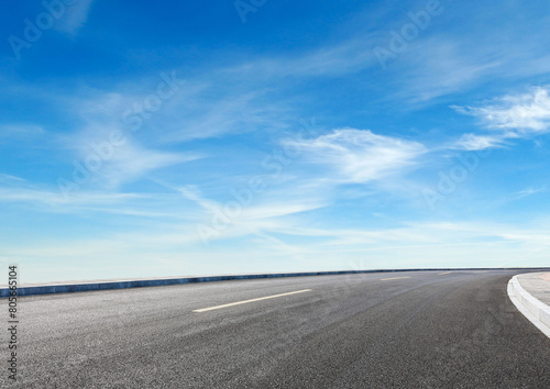 Modern highway cutting through Asian countryside under a clear blue sky