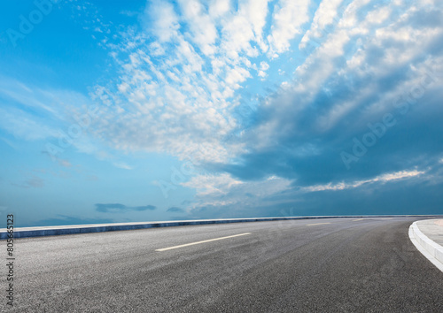 Modern highway cutting through Asian countryside under a clear blue sky