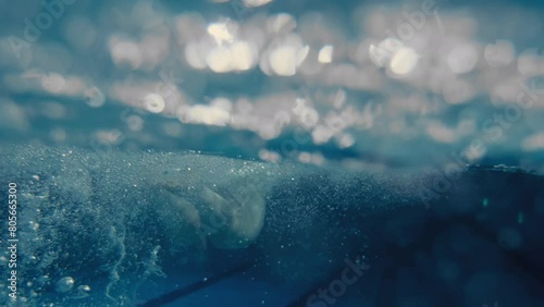 Woman swimming butterfly stroke in a pool from underwater