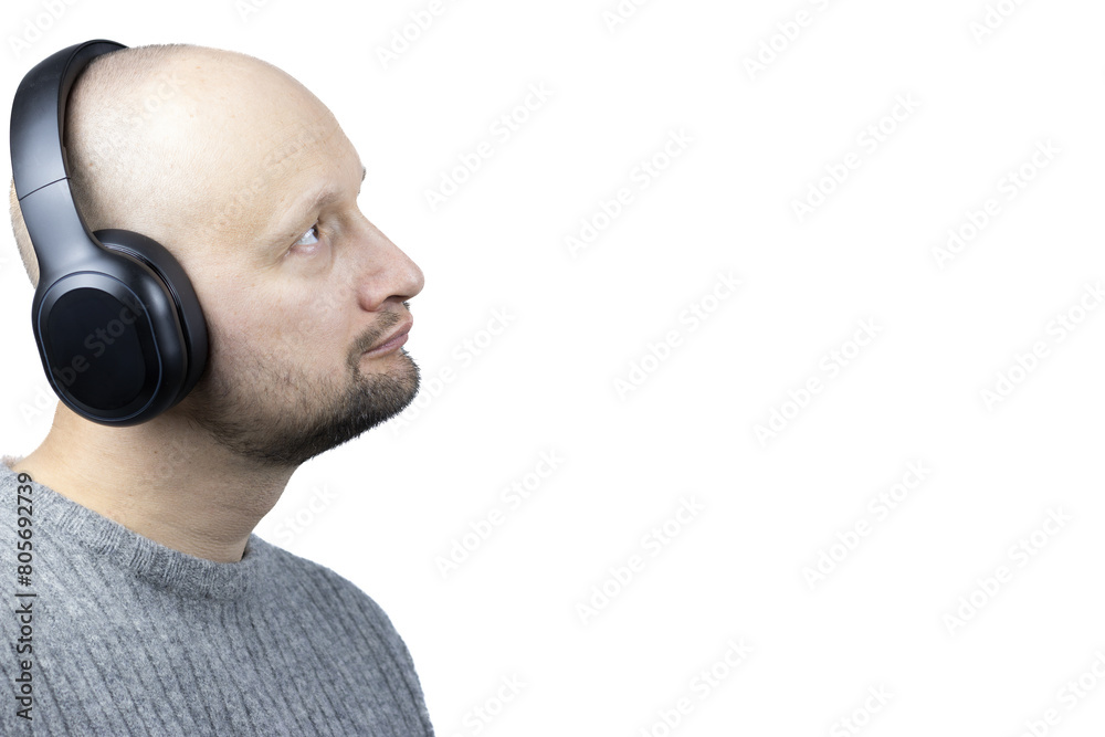 Fototapeta premium This is a captivating portrait of a man, set against a stark white background. He is clad in a finely knit grey wool sweater, his gaze directed upwards, embodying a sense of optimism and contentment
