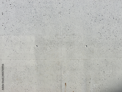 Concrete background texture. Raw material of a building wall with pores and spots. Real empty backdrop photographed from a house facade.