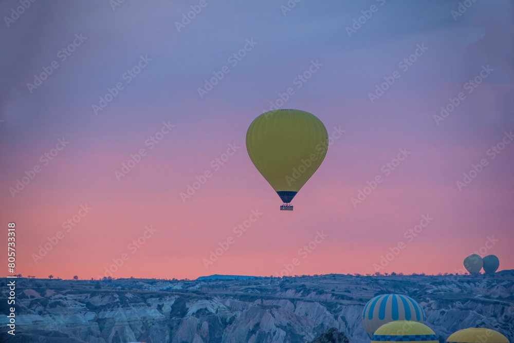 Sunrise in Cappadocia with colorful hot air balloons fly in sky over canyons, valleys morning tourist destination. Travel Turkey concept
