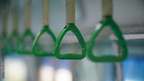 Green handles hanging inside the subway
