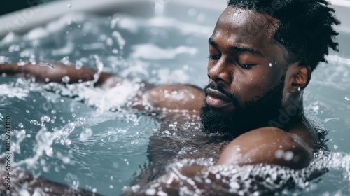 Athletic man taking a cold bath in a tub after a strenuous workout to soothe muscles