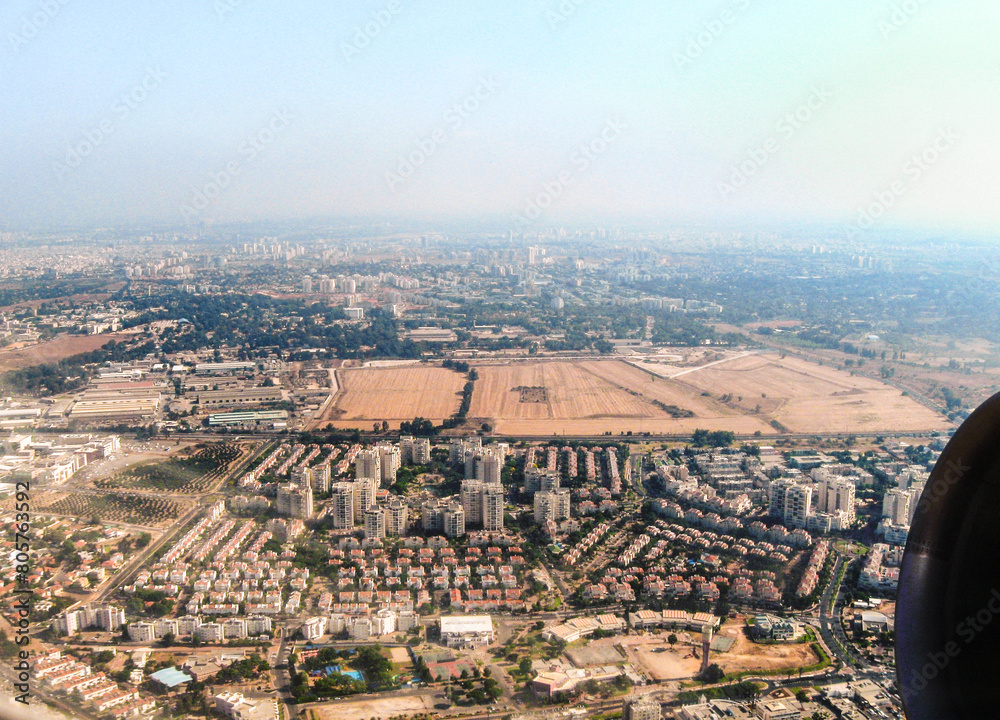 View  from the window of an airplane taking off from Ben Gurion Airport and flying over Tel Aviv city in Israel towards the Mediterranean Sea and Europe