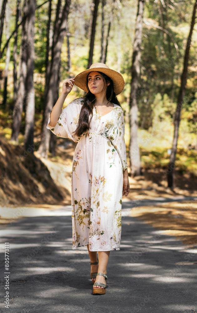 Young woman in a dress and straw hat in countryside