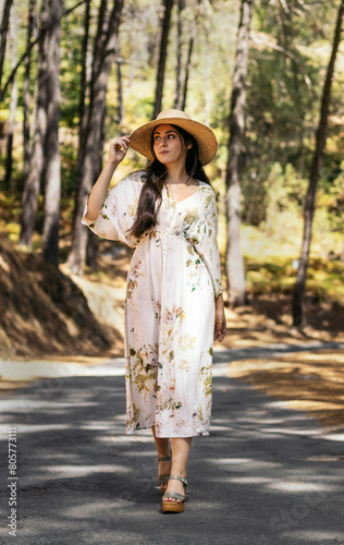 Young woman in a dress and straw hat in countryside