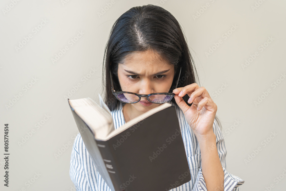 Presbyopia, hyperopia middle aged asian woman holding eyeglasses problem with vision blurred, female stare trying to read text on book at home, eye disease of old, eyesight farsightedness, health care Presbyopia, hyperopia middle aged asian woman holding eyeglasses problem with vision blurred, female stare trying to read text on book at home, eye disease of old, eyesight farsightedness, health care