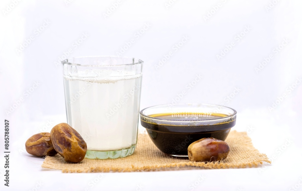 Date Palm Tree Juice or Khejur Ras in Glass with Phoenix Dactylifera Fruit and Liquid Date Palm Jaggery Isolated on White Background with Copy Space, Also Known as Date Palm Sap or Khejur Rosh Date Palm Tree Juice or Khejur Ras in Glass with Phoenix Dactylifera Fruit and Liquid Date Palm Jaggery Isolated on White Background with Copy Space, Also Known as Date Palm Sap or Khejur Rosh