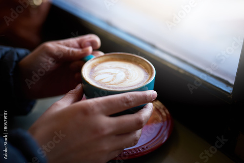 Hands, coffee and cappuccino in cafe for winter, travel and customer in restaurant for breakfast. Person, hot beverage and holding cup inside for warm, drink and barista art in New York city