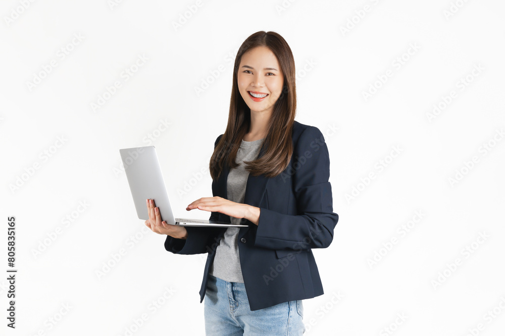 The cheerful and beautiful Asian businesswoman is holding a laptop and typing on the keyboard against a white background. The cheerful and beautiful Asian businesswoman is holding a laptop and typing on the keyboard against a white background.