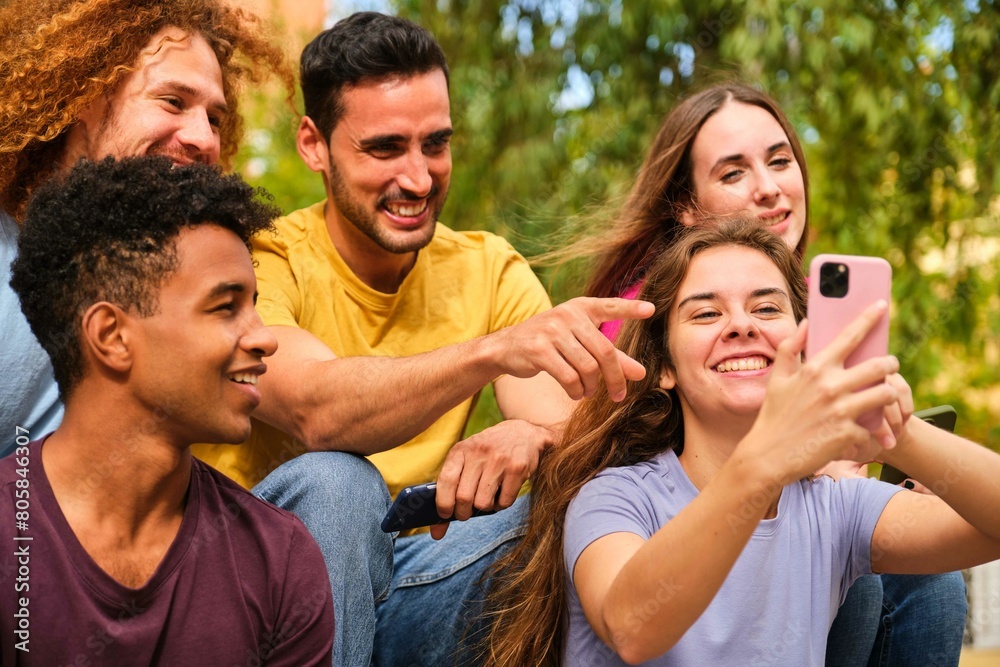 Group of young teenagers watching something funny on mobile phone screen at street. Group of young teenagers watching something funny on mobile phone screen at street.