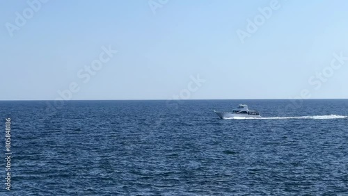 Wallpaper Mural A lone boat speeds across the vast blue ocean under a clear sky Torontodigital.ca