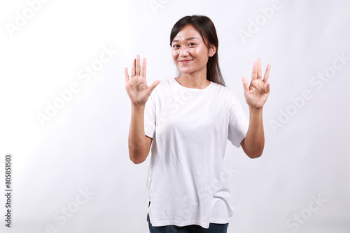 Smiling happy good-looking asian girl giving advice, showing nine fingers as explain rules, make point, standing white background