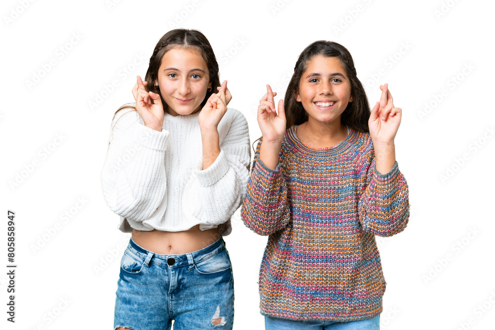 Friends girls over isolated chroma key background with fingers crossing Friends girls over isolated chroma key background with fingers crossing