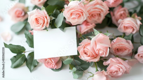 mockup of a white card beside pink rose bouquet, soft pastel tones 