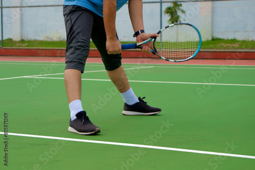 Close up of tennis player legs with black shoe playing on tennis court. Tennis player in the outdoor court