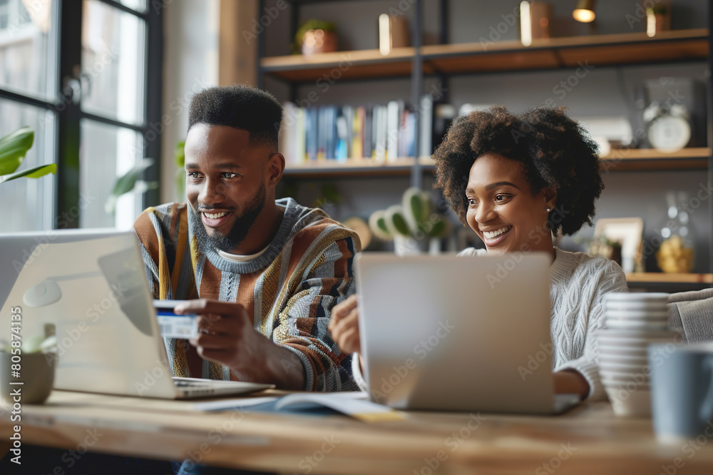 A happy young couple making a credit card payment on a laptop together at home. A happy young couple making a credit card payment on a laptop together at home.