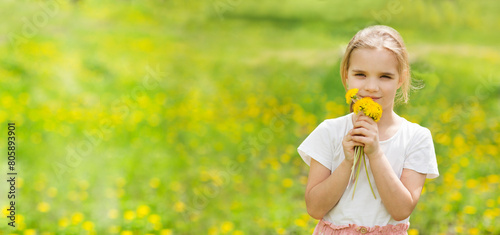 World Dandelion Day. Child girl closes her eyes with dandelions against a flowering field. banner. 