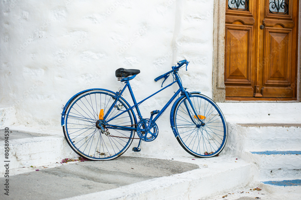 a blue old bicycle in the upper traditional city of Patmos with white cycladic houses Greece a blue old bicycle in the upper traditional city of Patmos with white cycladic houses Greece