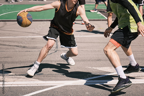 Men play street basketball on the asphalt in the city. photo