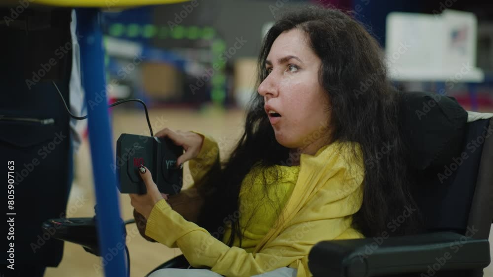 Female voter, woman with SMA in wheelchair votes in voting booth at polling station. US citizen with disability uses remote buttons for voting. Presidential Elections in the United States of America. Female voter, woman with SMA in wheelchair votes in voting booth at polling station. US citizen with disability uses remote buttons for voting. Presidential Elections in the United States of America.