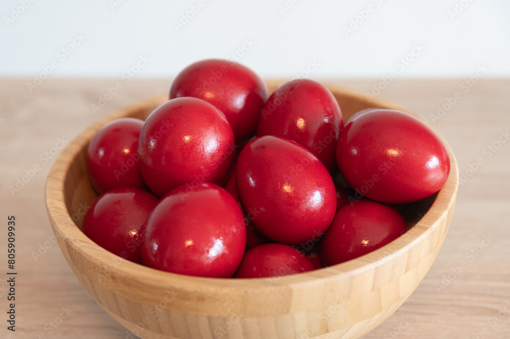 Red painted eggs in a wooden bowl