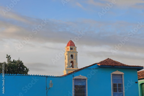 The Iglesia de San Francisco de Asis Church belfry seen over a blue colonial house on the Plaza Mayor Square in the late afternoon. Trinidad-Cuba-235 photo
