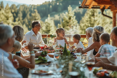 Big family at the table on the dinner on the backyard, group of people at a barbecue party at summer sunset.
