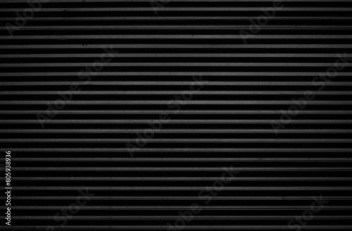 black tin iron corrugated wall with horizontal stripes from a metal profile of a metal sheet. Texture, background. grey wall fence texture for backdrop galvanized gray facade.
