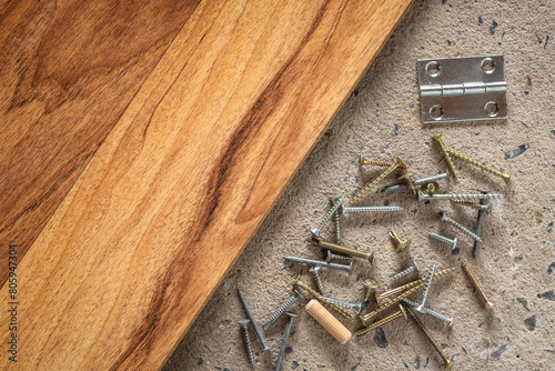 Screw, nail on concrete wood texture background. Closeup of screws and nails on cement and wooden floor, copy space.