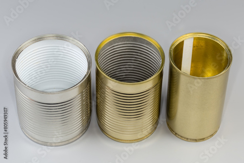 Open empty white and yellow tin cans on gray background