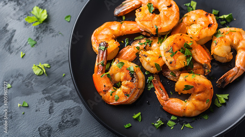 Sizzling Grilled Shrimp on Black plate with copy space for text, isolated on dark background. healthy food and recipe idea concept