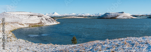 Panorama view on a snow covered landscape with lake Myvatn and volcanic explosion craters in autumn, Iceland
