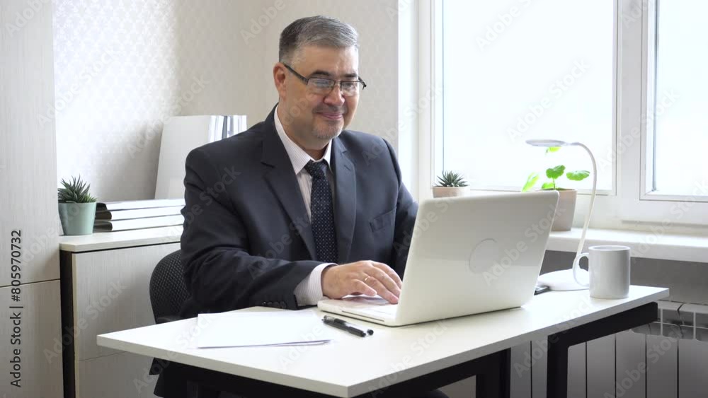 Businessman working in the office. He looks at the computer screen and smiles with satisfaction. Ideal for content related to business success, successful transactions and making good decisions.
Businessman working in the office. He looks at the computer screen and smiles with satisfaction. Ideal for content related to business success, successful transactions and making good decisions.