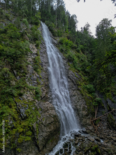 Long exposure of waterfall in lush forest at Kitzlochklamm, Austria