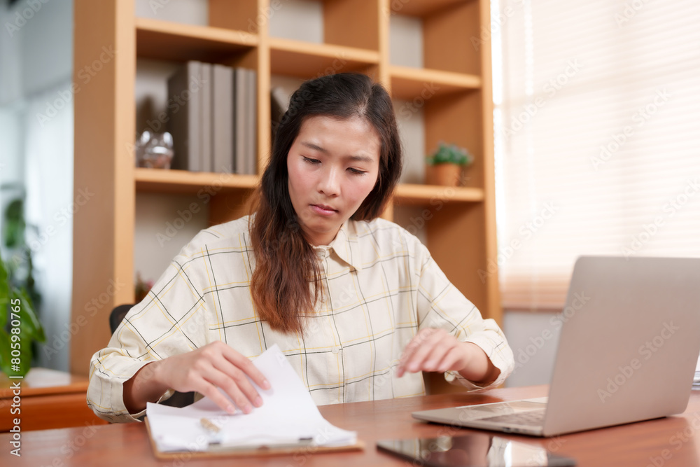 Office employee reviewing documents with a focused expression, suggesting careful analysis or scrutiny of paperwork. Office workers are working Office employee reviewing documents with a focused expression, suggesting careful analysis or scrutiny of paperwork. Office workers are working