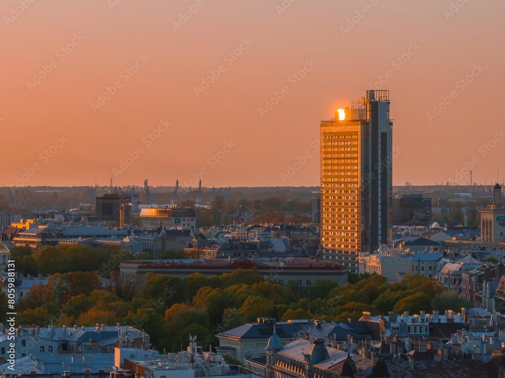 Naklejka premium Aerial panoramic sunset over Riga old town in Latvia. Beautiful spring sunset over Riga. Golden hour fire sunset.