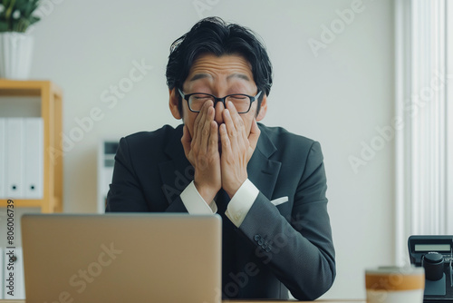 businessman in covers his face with both hands