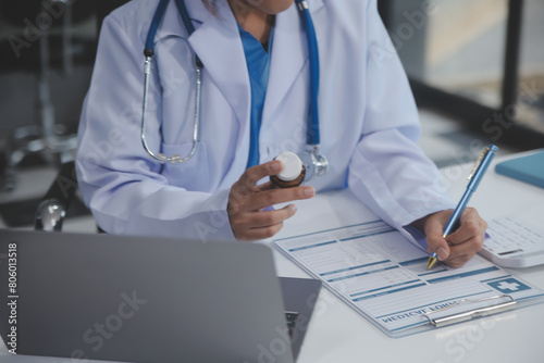 Cropped view of doctor in white coat holding bottle medication  prescribing pills to sick patient via online consultation. Family therapist recommend quality medicines. Healthcare  treatment concept
