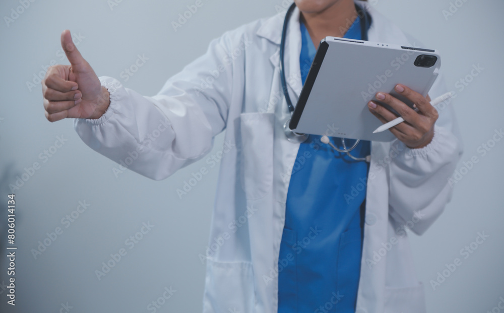 Woman doctor using tablet computer while standing straight in hospital Woman doctor using tablet computer while standing straight in hospital