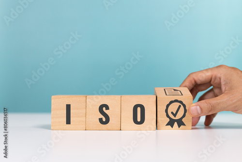ISO quality control certification, ISO standards verification, Quality certification concept. Hand hold check mark guarantee icon and wooden cubes with the abbreviation ISO