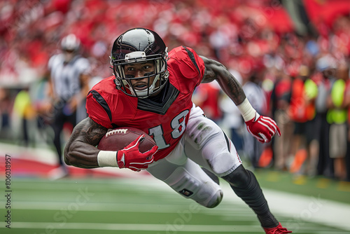 An American football player in a black helmet and red uniform holds a ball in his hand and runs at high speed on a curve. Football match