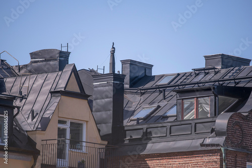 Black tin roofs, dorms on old houses at the sluice area in the district Södermalm, a sunny spring day in Stockholm
