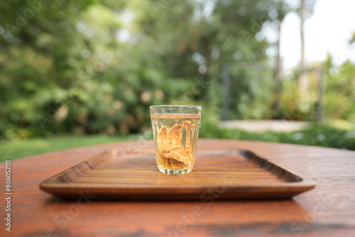 Bael tea glass cup and spoon on wooden table photo