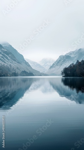 Serene mountain lake landscape with snow capped mountains in the distance