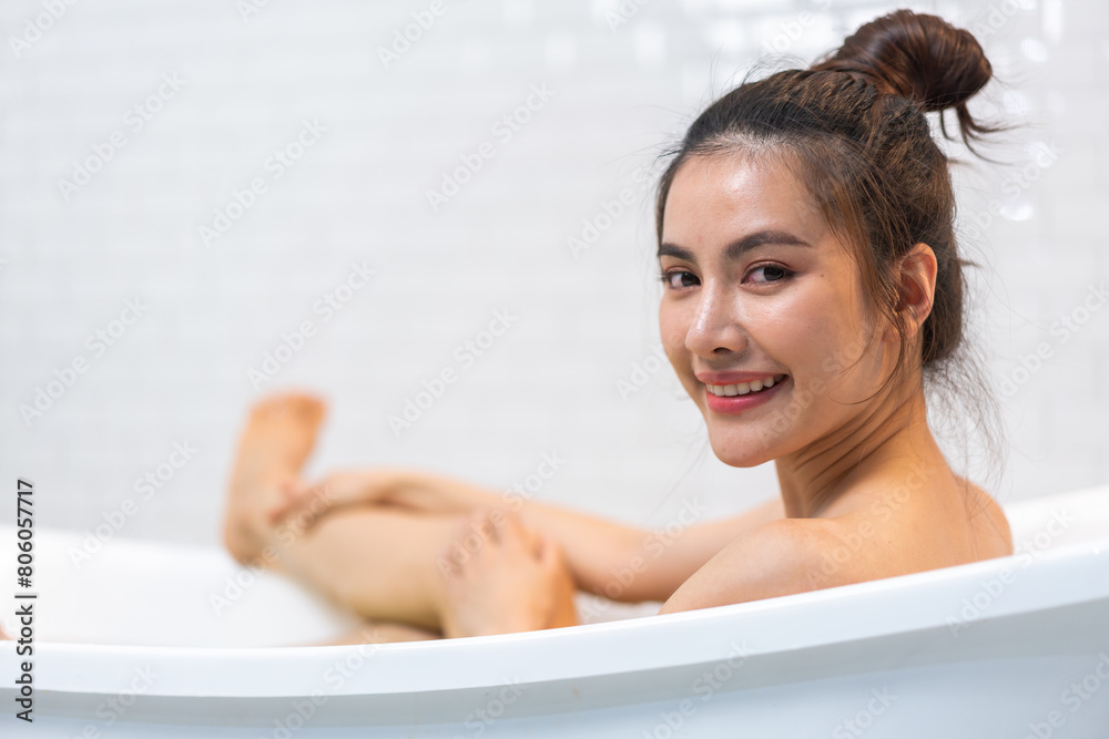 Obraz premium Portrait of smiling happy beauty asian woman enjoy relax clean healthy skin spa treatment scrub taking shower and bath with soap spa,shampoo bodycare product at bathroom.Self-love and Self-care