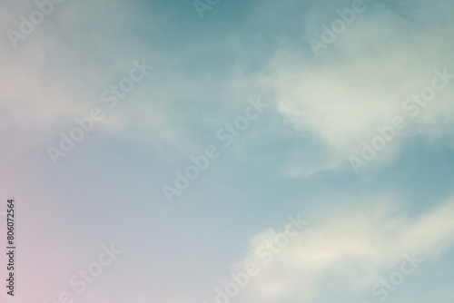 Soft white cloud illuminated by evening light over blue sky background in twilight time. 