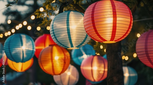 An array of vibrant paper lanterns hanging from trees at a cultural festival  casting a warm glow as dusk falls.