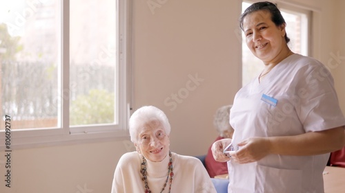 Caregiver smiling at camera next to old people in geriatric